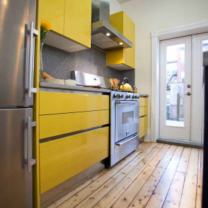 کابینت زرد ام دی اف هایگلاس در دکوراسیون آشپزخانه مدرن با کاشی بین کابینتی طوسی